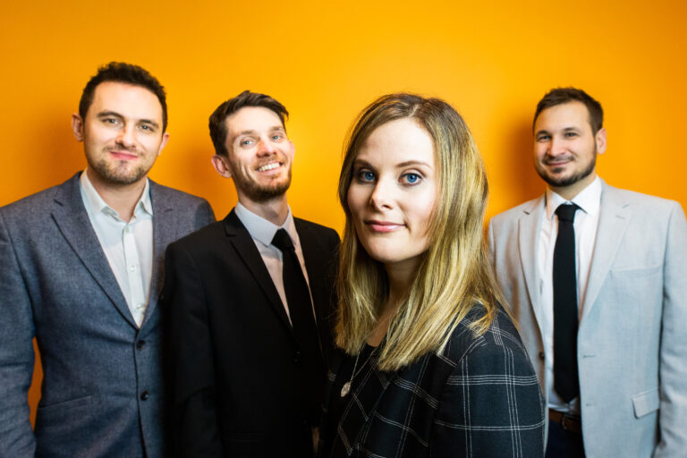 Rhythm of the night function and wedding band. Looking smart, staring at the camera with an orange background.