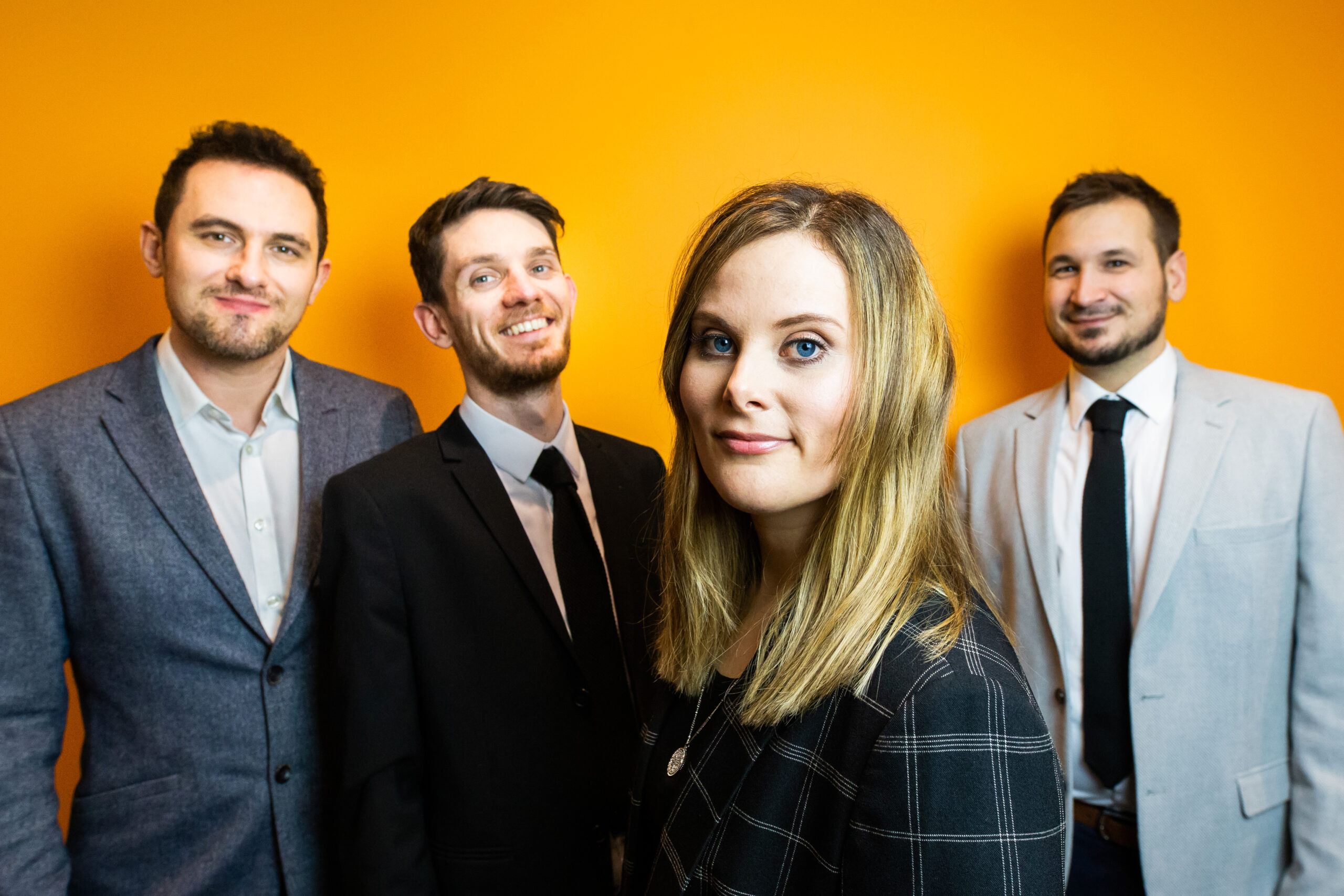 Rhythm of the night function and wedding band. Looking smart, staring at the camera with an orange background.